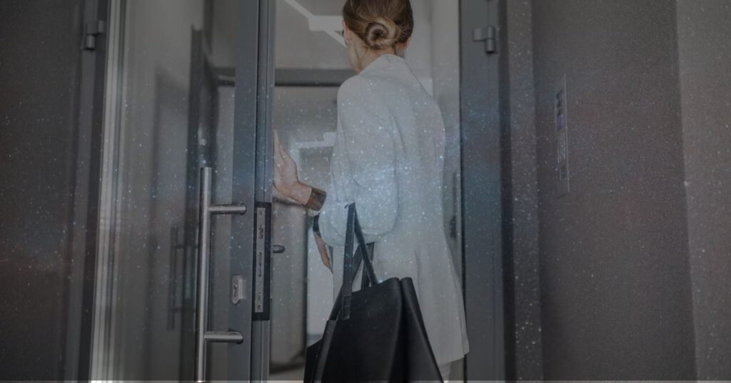 Woman opening door to office space.
